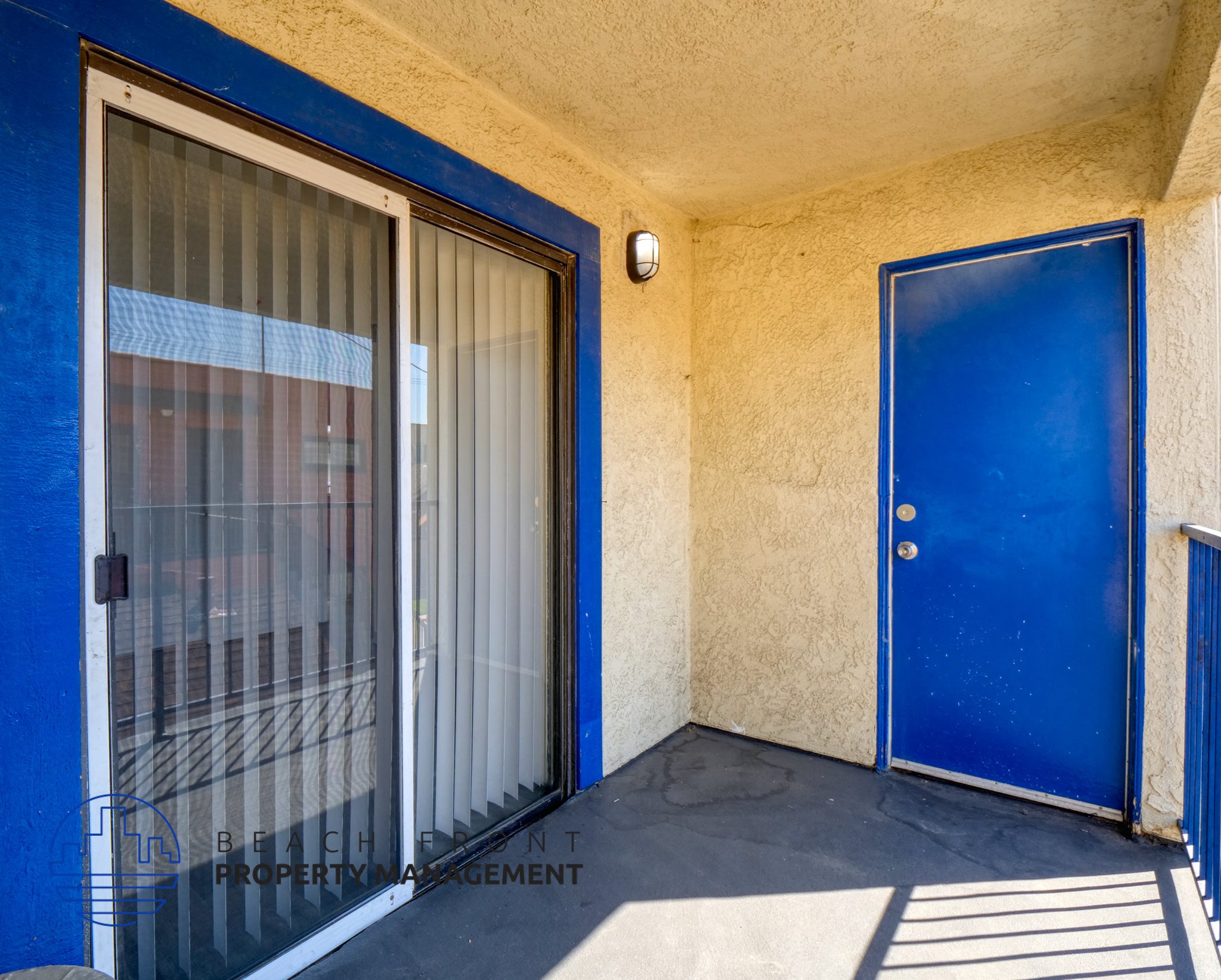 A blue door is on the right side of a window with a screen.